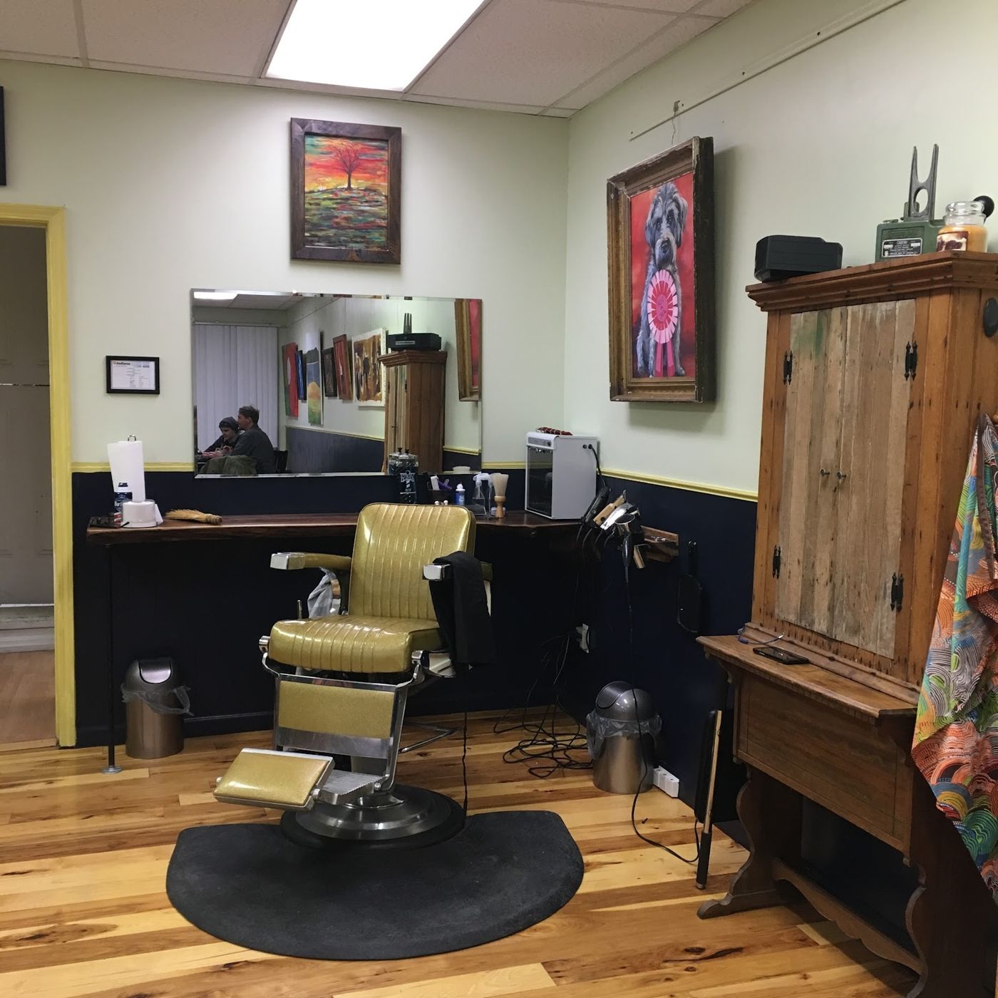 Inside House of Jane: a vintage barber chair, mirror and paintings on the walls